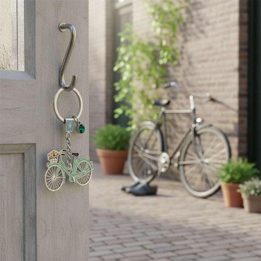 Nyckelring med strassten och pastellgrön cykel med text Holland och cykelkorg med tulpaner från Matix Souvenir Holland hängt på dörren