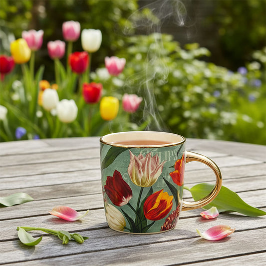 Mugg 27cl. serien "Pretty Tulips" grön/tulpaner i keramik av hög kvalitet med gulddetaljer från Matix Souvenir Holland på en trädgårdsbord