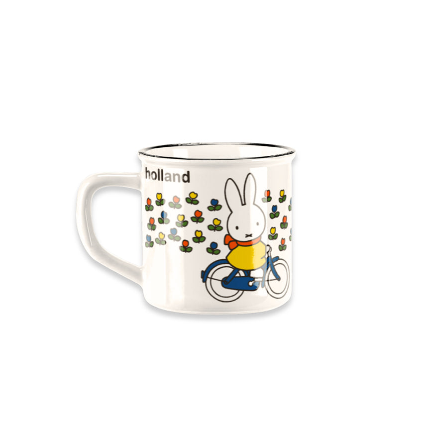 Miffy® retro mugg i offwhite keramik med svart kant och motiv av Miffy på cykel genom ett holländskt tulpanfält med orange-röd halsduk.