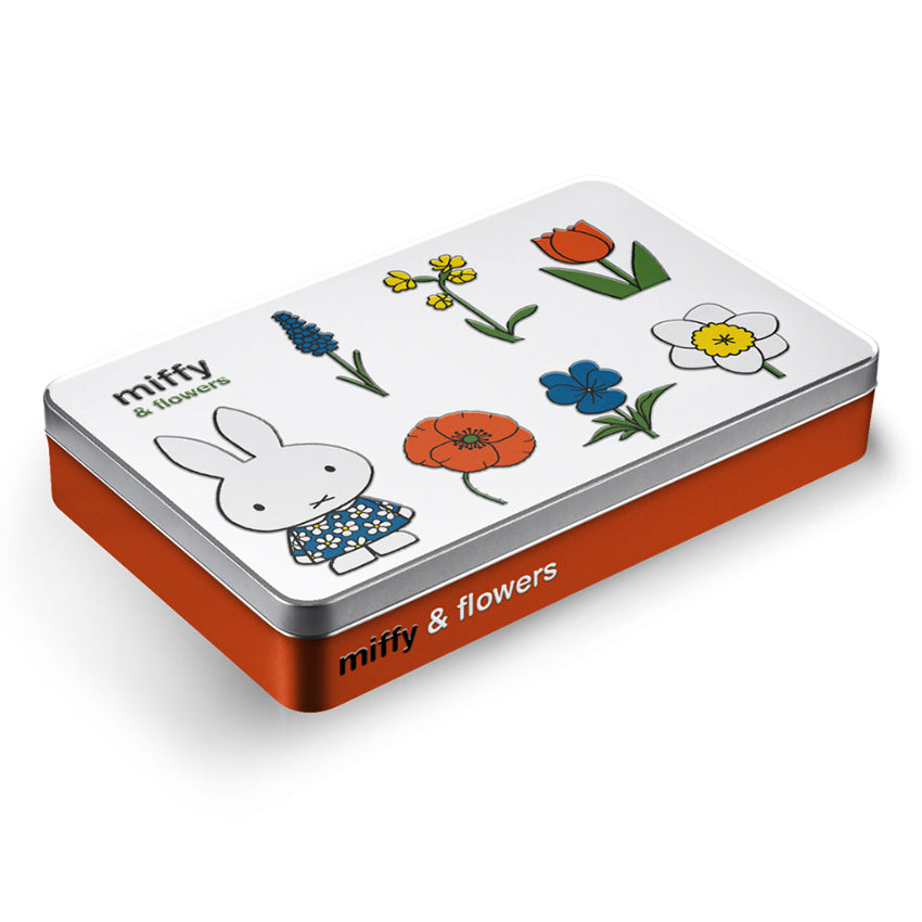 Miffy® färgpennsburk i metallic orange med reliefmotiv av Miffy i blommig klänning tillsammans med färgglada blommor och orange tulpan på vitt lock.