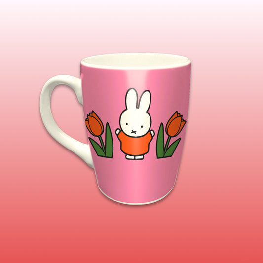 Miffy® Relax mugg i offwhite keramik med mörkrosa bakgrund, orange tulpaner och Miffy-motiv på båda sidor av muggen.