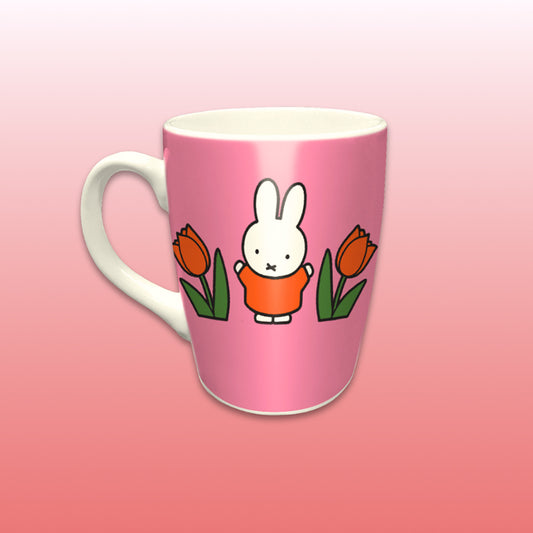 Miffy® Relax mugg i offwhite keramik med mörkrosa bakgrund, orange tulpaner och Miffy-motiv på båda sidor av muggen.