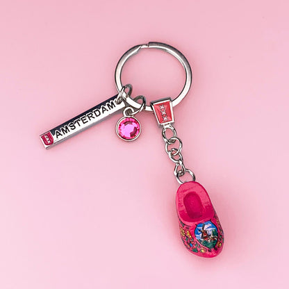 Roliga nyckelring med mörkrosa träsko och strassten och charm med texten Amsterdam