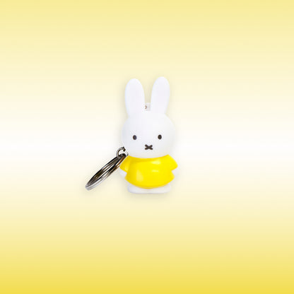 Miffy® 3D-nyckelring i matt vit plast med Miffy i gult och metallkedja med nyckelring.