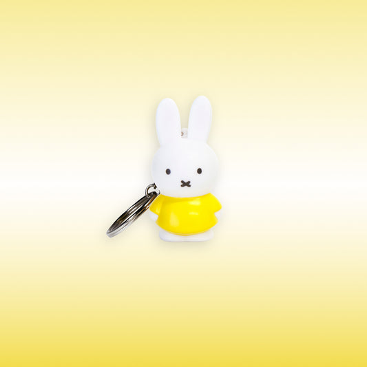 Miffy® 3D-nyckelring i matt vit plast med Miffy i gult och metallkedja med nyckelring.