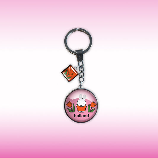 Miffy® glasnyckelring med rosa bakgrund, orange-röda tulpaner, välvt glas och liten tulpancharm i silverfärgad metallram.