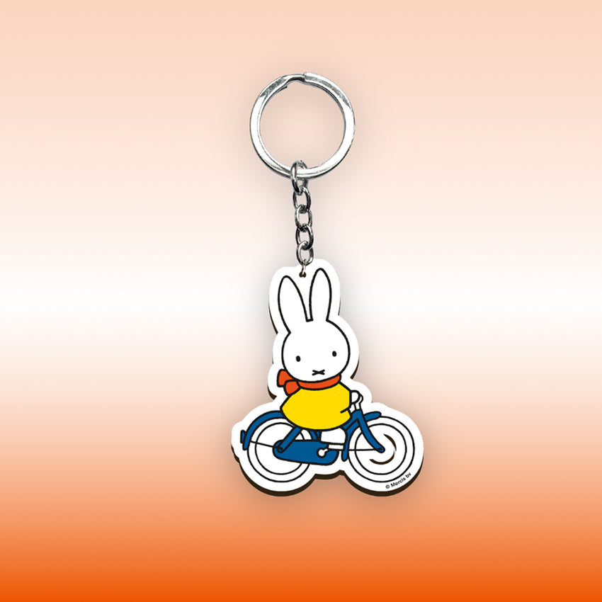 Miffy® nyckelring i laserskuren MDF med motiv av Miffy på cykel och metallkedja med nyckelring.