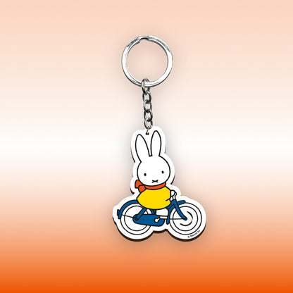 Miffy® nyckelring i laserskuren MDF med motiv av Miffy på cykel och metallkedja med nyckelring.
