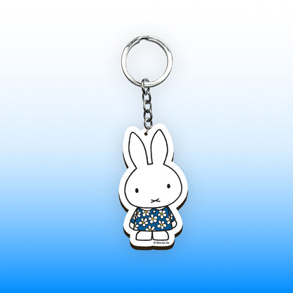 Miffy® nyckelring i laserskuren MDF med motiv av Miffy i mörkblå blommig klänning och metallkedja med nyckelring.
