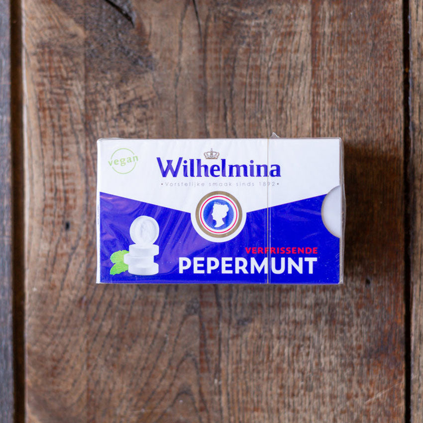 en ask med Wilhelmina-pepparmintpastiller på ett robust träbord