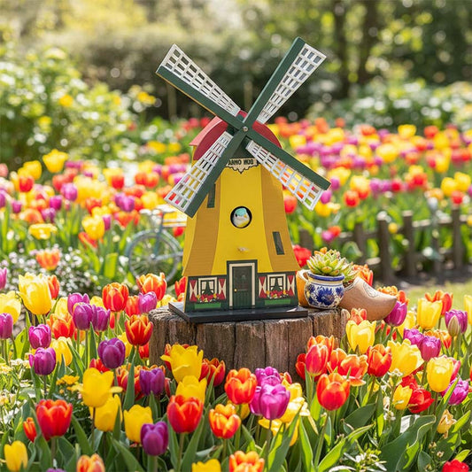 Fågelholk "Väderkvarn" / "Molen" gul/grön/röd från Matix Souvenir Holland i en tulpanrabatt med en liten fågel