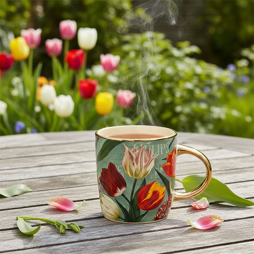 Mugg 27cl. serien "Pretty Tulips" grön/tulpaner i keramik av hög kvalitet med gulddetaljer från Matix Souvenir Holland på en trädgårdsbord