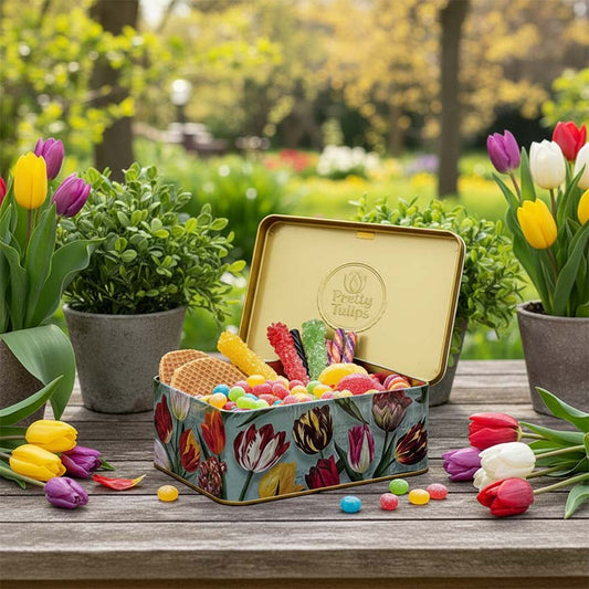 Kexburk serien "Pretty Tulips" tulpaner/grön och präglad logo från Matix souvenir Holland full med godis på ett trädgårdsbord