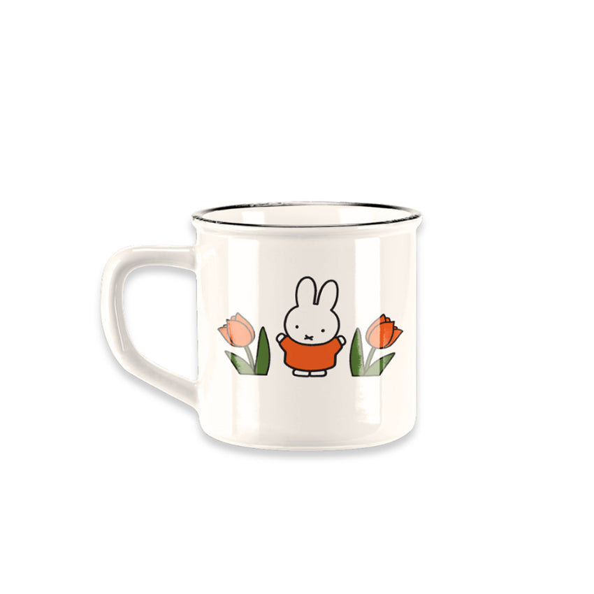 Miffy® retro mugg i offwhite keramik med svart kant, Miffy i orange kläder och orange-röda tulpaner på båda sidor av muggen.