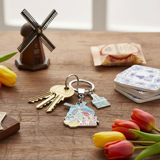 Nyckelring med färgsprakande tulpanskog, väderkvarn, träsko och Zaans hus i "Holland" från Matix Souvenir Holland på bordet.